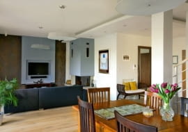 <B>Zaczęło się od minimalizmu - miało być nowocześnie i jednorodnie, bez zapożyczeń z innych stylów. Potem, w miarę upływu czasu, pomysł na aranżację domu Katarzyny i Filipa ewoluował. Pojawiły się klimaty kolonialne, tak lubiane przez gospodarzy.</B> <BR />WNĘTRZA. Dla ożywienia - stonowany błękit. Na ten kolor pomalowano ściankę z płyty gipsowo-karto- nowej (z płytką wnęką na telewizor) oraz ścianę z przewodami kominowymi. Ten sam odcień niebieskiego można wypatrzyć na wiszącej obok kominka grafice Jerzego Nowosielskiego.