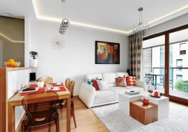 <B>Projektując mieszkanie Anny i Janusza, dużą wagę przyłożono do oświetlenia. Wnętrza są nie tylko jasne. Światło modeluje też przestrzeń, wyodrębnia z niej strefy o różnej funkcji, a nawet wizualnie poprawia niekorzystny kształt pomieszczeń.</B> <BR />Salon połączony z kuchnią, choć długi i wąski, wcale na taki nie wygląda. To dlatego, że umiejętnie ustawiono meble, np. spory stół prostopadle do długiej ściany, natomiast stolik kawowy - centralnie. W ten sposób wizualnie skrócono pomieszczenie. Taśmy LED, zainstalowane za gzymsami pod sufitem, dodatkowo optycznie poprawiają kształt wnętrza i podkreślają część wypoczynkową.