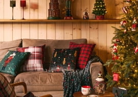 Stwórz wygodny kącik do odpoczywania. Ułóż na sofie poduszki i pled z motywem świątecznym, a na stoliku słoik z Mikołajem pełen pierników.