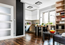 <B>Urządzanie niewielkiej kawalerki wymagało od Julii, Jana oraz projektantki pomysłowości i cierpliwości niczym skomplikowana układanka. Opłacało się. Gospodarze mają teraz osobną sypialnię, a we wciąż przestronnej strefie dziennej wystarcza miejsca i dla domowników, i dla gości.</B> <BR />Aneks kuchenny urządzono w pokoju dziennym. Zabudowa w kształcie litery U zapewnia dużo miejsca do przechowywania i do pracy. Wysoki słupek po lewej stronie pomieścił lodówkę z zamrażarką i (u góry) pojemną szafkę na rzadziej używane rzeczy. Wszystkie wiszące schowki sięgają do sufitu.