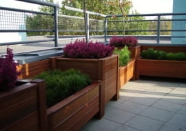 Drewniane skrzynie z roślinami. Można w nich sadzić rośliny na stałe oraz wstawiać mniejsze doniczki - wymieniane w zależności od sezonu