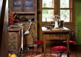 Meble tylko niezbędne - wszystkie bardzo proste, niektóre ozdobione nieskomplikowanym malunkiem przedstawiającym rośliny typowe dla danego regionu. Jako dekoracja - dużo kwiatów i ziół, ozdobna figurka.