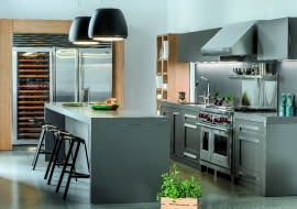 Chłodna stal. Model NY nawiązuje do klasycznych amerykańskich kuchni. Frezowane fronty w matowym, grafitowo-brązowym lakierze i stalowe elementy zostały zestawione z ciepłym, dębowym fornirem. Proj. Adam Pulwicki. meble-zajc.pl