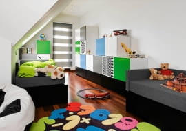 <B>Pokój Mateusza i Mikołaja jest duży, ale  długi i ze skośną ścianą. Rodzice nie mogli sobie poradzić z urządzeniem tak nieustawnego wnętrza i właściwie zapewnili synom tylko wygodne miejsca do spania. Nic więc dziwnego, że chłopcy traktowali pokój jako sypialnię, a bawili się w salonie, zagracając to reprezentacyjne pomieszczenie swoimi zabawkami.</B> <BR />PO ZMIANIE. Pokój jest wygodny i wesoły. Stare łóżka zastąpiono tapczanami ze schowkami na pościel, a przy dwóch ścianach stanęły szafki na chłopięce skarby. Dzięki przemyślanemu oświetleniu i żywym kolorom we wnętrzu zrobiło się jaśniej i radośniej.