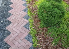 Nawierzchnię dróżek można pokryć brukową kostką klinkierową, betonową, kamienną, brukiem drewnianym, żwirem lub tłuczniem