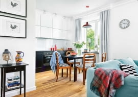 ŚCIANĘ NAD BLATEM KUCHENNYM chroni tafla hartowanego szkła w takim samym kolorze jak wiszące szafki. Na podłodze leżą olejowane dębowe deski; listwy przypodłogowe są zrobione z polakierowanej na biało płyty MDF.