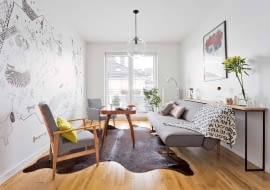 Lekkie meble, niezagracona przestrzeń, jasna neutralna kolorystyka - to wszystko sprawia, że niewielki pokój o wydłużonym kształcie wydaje się większy i bardziej proporcjonalny, niż jest w rzeczywistości.