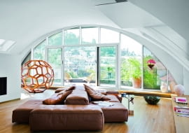 Pod kolebkowym sufitem salonu sofa Extrasoft Piero Lissoniego (Living Divani). Ażurowa struktura to wykonana z drewna huanghuali rzeźba 'Divine proportion' chińskiego artysty Ai Weiwei`a.