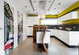 Białe meble kuchenne i ściany w musztardowym kolorze.