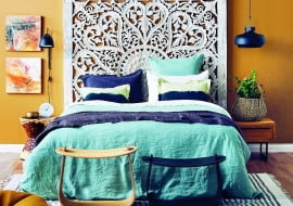 Główna ozdoba tej sypialni - efektowny zagłówek. Aby go odpowiednio wyeksponować, ścianę za nim pomalowano na kontrastowy kolor, który wydobył piękno ażurowego wzoru.
