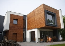 Nadwieszona część bryły sypialni na piętrze tworzy zadaszenie tarasu na parterze, umożliwiając korzystanie z niego nawet w deszczowe dni