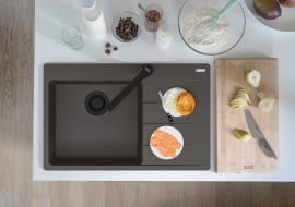 Franke zlewozmywak z czarnymi matowymi elementami i baterią.