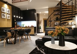 Mieszkanie po remoncie zyskało loftowy charakter z użyciem betonu, czerni i drewna.