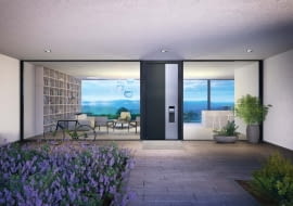 Nowoczesne drzwi mają często zakryty profil skrzydła, dzięki czemu tworzą jedną płaszczyznę z ościeżnicą. Na zdjęciu: drzwi aluminiowe ThermoCarbon, rama z kompozytu karbonu i włókna szklanego, Ud = 0,47 W/(m?K), klasa RC3, cena od 22 293 zł (netto), HÖRMANN