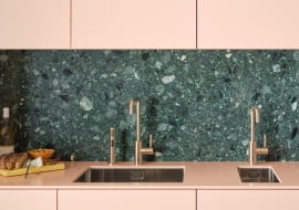 Meta Square w kolorze Brushed Champagne (22-karatowe złoto) jako bateria jednouchwytowa z boczną dyszą płuczącą (z lewej i prawej strony). Pośrodku armatura pojawia się jako kran barowy.