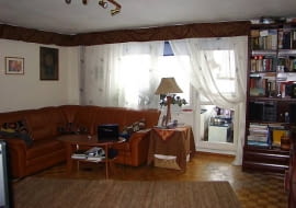 PRZED ZMIANĄ. Pokój był przeładowany meblami i drobiazgami. W dodatku oszpecały go rury c.o. biegnące przy oknie i pod sufitem. Zrobione własnym sumptem lambrekiny, które miały je zasłaniać, też nie dodawały wnętrzu urody.