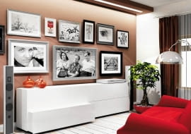 <b>W pokoju dziennym pod zawieszonym na ścianie płaskim telewizorem stoi długa komoda z lakierowanymi na biało frontami. Ściana ma zimny beżowo--szary odcień i na razie jest pusta. Proszę o radę, co zrobić, żeby telewizor nie stanowił jej głównego elementu i mniej rzucał się w oczy?</b><br/> Na ścianie wokół odbiornika proponuję zawiesić zdjęcia lub obrazki oprawione w delikatne ramki. Taka galeria zapełni pustą przestrzeń i odciągnie uwagę od ekranu, a zarazem nada całemu wnętrzu indywidualny charakter. Można też zamontować lekkie półki o ciekawej formie. Kiedy ustawimy na nich na przykład książki lub rośliny w ciekawych doniczkach, ściana stanie się kolorowa, a telewizor - mniej widoczny.