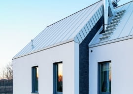 Dom widziany od ulicy dojazdowej – zgrabne rozdzielenie bryły na dwie przesunięte względem siebie części uatrakcyjniło wygląd budynku