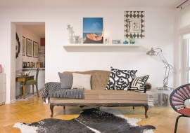 <B>Najprostszym kluczem do stworzenia nastroju jest umiejętnie dobrany detal. Błyskawiczna metamorfoza tego mieszkania udowadnia, że wystarczy naklejka, naczynie w odpowiednim kolorze, rozrzucone tu i ówdzie bombki lub jabłka, kilka figurek i od razu widać, że święta są tuż za progiem. W dodatku jest to patent uniwersalny. Tak samo łatwo przeobrazimy wnętrze na powitanie wiosny albo na urodziny babci.</B> <BR />SALON PRZED ZMIANĄ. Na co dzień w pokoju dziennym panuje stylowa mieszanka: przepastna kanapa w stylu retro i fotel z lat 50. z wyplatanym z tworzywa sztucznego siedziskiem. We wnętrzu dominują chłodne odcienie beżu i niebieskiego, do tego kropla czerni, a w tle biel.