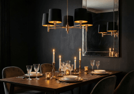 Nad stołem zawisła klasyczna lampa Ponte w eleganckim czarnym kolorze z zewnątrz i złotym w środku. Jej ciepłe światło wzmocnione zostało blaskiem świec.