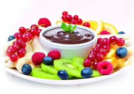 Czekoladowe Fondue: Porzeczki zanurzamy w gorącej masie, trzymając za ogonki, inne drobne owoce - na widelczyku.
