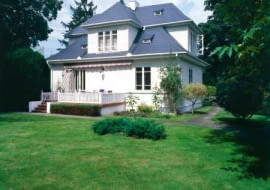 Drewniany modrzewiowy dom otoczony ogrodem utrzymanym w charakterze parku. Kilka lat temu elewację budynku pomalowano na biało, a dach pokryto łupkiem w kolorze grafitu układanym na łatach i kontrłatach przybitych do papy na deskowaniu.