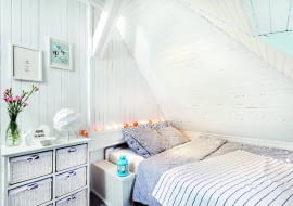 Nowe meble to okazyjne zakupy, które pozwoliły znacznie obniżyć koszt metamorfozy. Poszukiwanie łóżka trwało dość długo, bo mebel (bez zagłówka) musiał mieć ściśle określone wymiary - to ze względu na rury, które po obudowaniu tworzą półkę nad łóżkiem i 'stolik' nocny. Odpowiedni mebel wraz z materacem udało się niedrogo kupić w polskiej firmie. Komoda z koszykami była przeceniona prawie o połowę. Lampki cotton balls, podobnie jak niebieski lampionik, to wyłącznie nastrojowa dekoracja. Tę część wnętrza oświetla halogen zamontowany na skośnym suficie.