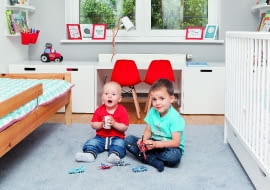 Na podłodze leży szary dywan, który pozostał z poprzedniego wystroju. Jest miękki i ciepły, chłopcy mogą się więc na nim bawić. W drugiej części pokoju pojawił się dekoracyjny dywanik z motywem ulic.