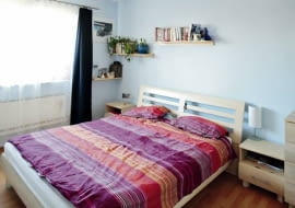 Sypialnia jakich wiele. Centralnie ustawione łóżko z szafkami nocnymi po bokach, a na ścianach pomalowanych na chłodny błękit - półeczki na książki i drobiazgi. Jest tu wszystko, co potrzebne do wypoczynku. Prócz nastrojowej atmosfery.