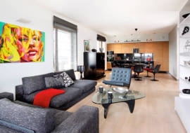 W kuchni zainstalowano listwy oświetleniowe z halogenami, nad stołem jest lampa wisząca, a w części wypoczynkowej - kinkiety i reflektorki. We wnętrzu dominują ciemne szarości i czerń rozjaśnione dużymi płaszczyznami bieli i kremowego beżu.