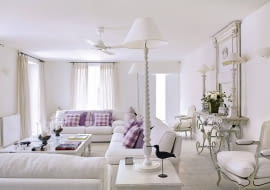 Provencal holiday house with courtyard garden SLOWA KLUCZOWE: day colour building interior living room white sofa window curtain pole curtains animal bird chair mirror console table fresh coffee table purple cushion flooring radiator checked lilac overview furniture seating white room