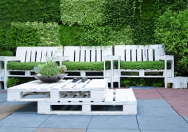 Poprzez kreatywne łączenie pomalowanych palet wykonamy meble o różnorodnych kształtach. Do pracy potrzebne nam będą narzędzia, takie jak wkrętarka oraz młotek. Funkcjonalny stolik ogrodowy zbudujemy poprzez trwałe połączenie dwóch ułożonych na sobie platform. Jego mobilność zwiększymy montując od spodu kółka. Z drewnianych elementów możemy również stworzyć oryginalny fotel, którego konstrukcję stanowić będą cztery odpowiednio połączone ze sobą palety. Oparcie takiego fotela warto dodatkowo wzmocnić płytą OSB, a jego siedzisko wyposażyć w grube, wygodne, kolorowe poduszki.