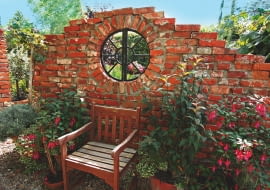 Ogrodowa klasyka - ścianka z cegły. Aby nie zamykała widoku na ogród, pozostawiono w niej otwór na okno.