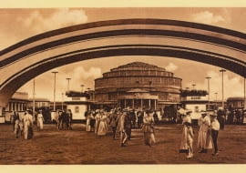 Pocztówka wydana przez Theodora Lichtenberga: Hala Stulecia w 1913 roku od strony wejścia głównego na teren wystawy. Na pierwszym planie widać bramę wejściową (źródło: "Spacer po dawnym Wrocławiu. Pocztówki z lat 1885-1942" - Via Nova)