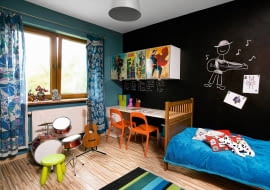 <B>Tymek rósł, zmieniały się jego zainteresowania i tryb życia, a w zajmowanym przez niego pokoju czas jakby się zatrzymał. Rodzice uznali, że nie ma już na co czekać i zawezwali na pomoc stylistkę.</B> <BR />PO ZMIANIE. Tymek bardzo lubi kolor czarny i chciał go mieć w swoim pokoju, stylistka zaproponowała więc pomalowanie na tę barwę jednej ze ścian (użyto farby magnetycznej, po której można także pisać). Fronty szafki nad biurkiem zostały ozdobione kolorowymi naklejkami z wizerunkami komiksowych bohaterów. Wyeksponowane miejsce pod oknem zajęły perkusja i gitara, na których chłopiec uczy się grać.