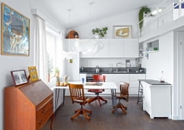 Otwarta kuchnia jest częścią strefy dziennej. Są w niej proste białe szafki (zrobione przez firmę z Mławy) oraz meble, które pasują stylem również do salonu: krzesła biurowe z Ameryki i biała szafka z targu staroci. Na podłodze - dąb olejowany. Blat i pas kamienia na ścianie to chiński granit. Sposób na oszczędności: stół to pomalowana na biało płyta OSB, do której przykręcono metalowe nogi z dawnego biurka córki.