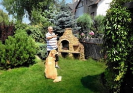 Pan Tomasz w swoim ogrodzie z Howardem - ośmioletnim psem rasy Hovawart.