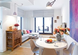 Jasny pok dzienny ożywiają poduszki (z pakamera.pl) leżące na narożnej kanapie (Vieri Divani). Ich odcienie dobrano do kolorystyki obrazu młodego artysty Philippe'a Rębosza. Gospodarze kupili go na Targowisku Sztuki w Arkadach Kubickiego w Warszawie, gdzie swoje prace wystawiają studenci i absolwenci tutejszej ASP.