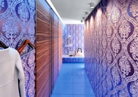 <b> DŁUGI I WĄSKI. Jedna ze ścian przedpokoju, wykończona wzorzystą tapetą, służy tylko jako ozdoba - nie ma na niej nawet lustra. Na drugiej ścianie znajduje się kilkoro drzwi. Wbrew pozorom nie za wszystkimi kryją się szafy i szafki - dwoje z nich prowadzi do kolejnych pomieszczeń (jeśli przedpokój jest dobrze oświetlony sztucznym światłem, można zrezygnować z przeszkleń). Zamiast klamek zamocowano na nich takie same uchwyty jak w drzwiach do szaf - długie pionowe relingi. </b> <BR /> Oświetlenie jest dyskretne, ale jasne. Z lewej strony zainstalowano listwę LED, z prawej - halogeny (w podwieszanym suficie oraz w ścianie, tuż nad podłogą).