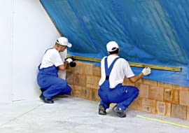 Układanie folii paroizolacyjnej. Należy przy tym zadbać o to, by szczelnie połączyć ją z innymi elementami konstrukcji domu - tu ze ścianą szczytową i kolankową