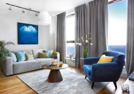 Między oknami stolik z marmurowym blatem Pelegie, zaprojektowany przez Dorotę Koziarę dla Comforty (Mesmetric). Fotel wykonany przez tapicera Kazimierza Miąskowskiego, zasłony WinDekor.