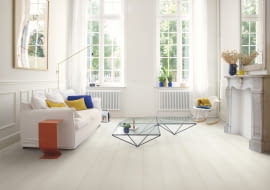 Biała podłoga rozświetla pokój i powiększa go optycznie. Białe panele podłogowe laminowane marki Quick-Step z kolekcji Signature.