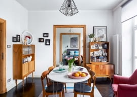 Taki widok jest możliwy tylko w mieszkaniu w amfiladzie. Po obu stronach drzwi stoją prawdziwe meblowe zabytki z lat pięćdziesiątych XX wieku. Z prawej - szafka kupiona za zaledwie 200 zł na targu staroci, z lewej - szafka sprezentowana pani domu przez jej brata. Obie są wymarzonym miejscem na drobiazgi sprzed lat i na piękne szkło. Fioletowy fotel Magda odziedziczyła po wujku.