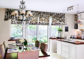 <B>Wydawałoby się, że lambrekin może tworzyć parę wyłącznie z tradycyjnymi, bogato drapowanymi zasłonami, a jego związek z nowoczesnymi roletami rzymskimi nie będzie równie udany. Otóż nie! Dowodem jest prezentowane wnętrze.</B> <BR />Rolą miękkiego lambrekinu jest zasłonięcie nadproża nad wnękami okiennymi i optyczne podniesienie sufitu w dość niskim pomieszczeniu. Jednocześnie jest on efektownym zwieńczeniem całej aranżacji okiennej - uszytych z tej samej tkaniny rzymskich rolet, które wiszą w oknach i drzwiach balkonowych.