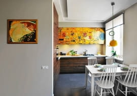 <B>Podczas studiów Danuta malowała i sprzedawała kopie obrazów Gustava Klimta i w ten sposób zasilała swój skromny budżet. Tak zżyła się z twórczością tego malarza, że uczyniła z niej motyw przewodni w aranżacji swojego pierwszego małżeńskiego mieszkania.</B> <BR />Kuchnię otwarto na pokój dzienny. Na fronty górnych szafek, widocznych z kąta wypoczynkowego, nadrukowano fragment obrazu Pocałunek Gustava Klimta. Wnętrze wygląda przez to elegancko, a praktyczna funkcja mebli zeszła na drugi plan. Do kolorystyki nadruku nawiązuje filcowa lampa nad stołem projektu Joanny Pytlewskiej-Bil.