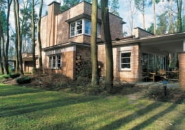 Widok na dom od strony ogrodu. Architekci dołożyli starań, by podkreślić urodę leśnego otoczenia budynku. Kształty elewacji i formę domu 'wpisano' pomiędzy rosnące wokół sosny i dęby.