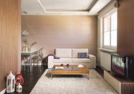 Pani Iwona mieszka teraz w Brukseli, jednak w Warszawie czeka na nią odnowione mieszkanie. To jej azyl, miejsce do życia na stałe. Urządzaniem wnętrz zajęła się projektantka, a większość rzeczy niezbędnych w nowym domu gospodyni kupiła w internecie i zobaczyła dopiero, gdy mieszkanie było już gotowe. <BR /> MIESZKANIE. W salonie dominują brązy i beże z elementami złamanej bieli. Fragmenty ścian wykończono fornirem z drewna orzecha amerykańskiego, a podłogę - trwałym i dekoracyjnym parkietem przemysłowym z czarnego dębu wędzonego. Ściana nad kanapą jest wyłożona szerokimi pozio- mymi pasami z płyt gipsowo-kartonowych.