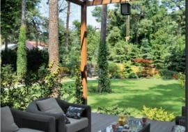 A Na tyłach domu znajduje się duży taras zadaszony drewnianą pergolą