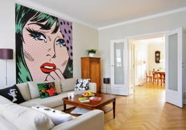 Pan Marcin jest zdeklarowanym miłośnikiem modernizmu. Mieszkanie w łódzkiej kamienicy z lat 30. XX wieku odnowił, dbając o każdy zachowany detal. Dzięki współczesnym dodatkom wystrój zyskał szczyptę pikanterii. Trzeba naprawdę dużo wyczucia, by różne elementy tak do siebie dopasować! <BR /> MIESZKANIE. Ulubionym kolorem gospodarza jest biel - i to ona dominuje w całym mieszkaniu. Urządzanie pokoju dziennego zaczęło się od przyklejenia fototapety z reprodukcją popartowskiego plakatu autorstwa Roya Lichtensteina, amerykańskiego malarza i grafika bardzo cenionego przez pana Marcina. Szafka z początku XX wieku (w rogu) to nabytek z aukcji internetowej.