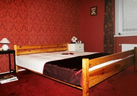 <B>Gospodarze od dawna mieli wizję wystroju sypialni. zaczęli ją nawet realizować, ale z braku czasu odłożyli pracę na potem. Gdyby nie pomoc naszej stylistki, ten wstępny etap trwałby pewnie do dziś.</B> <BR />PRZED ZMIANĄ: Tapeta w barokowy wzór i ściany w odcieniu burgunda wprowadzały do sypialni pałacowy przepych. Niestety, pozostałe elementy wystroju, na przykład sosnowe łóżko, były zupełnie z innej bajki.